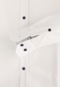 Witte dress shirt met een textuurstof, contrasterende marineblauwe knopen en een gladde afwerking op de manchetten. Knoopsluiting, lange mouwen.