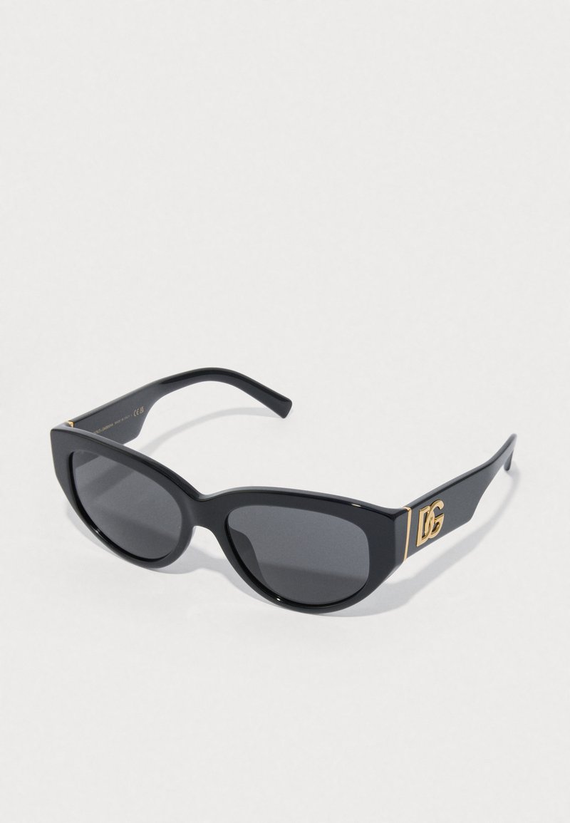 Óculos de sol pretos com uma moldura larga em forma de gato, lentes escuras e o emblema dourado DG nas hastes. Textura de plástico suave e acabamento brilhante.
