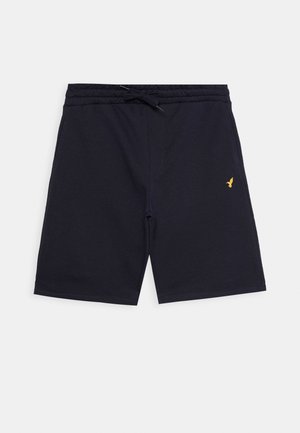 Tumesinine lühikesed püksid, mis on valmistatud puuvillasegistusest, elastse vöökoha ja nööriga, ning vasakul jalal on väike tikitud logo.