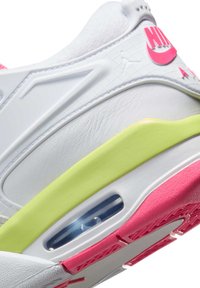 Vit sneaker med rosa och gröna accenter. Har en texturerad läderöverdel, synlig luftkuddar och mönstrad gummiklädd sula.