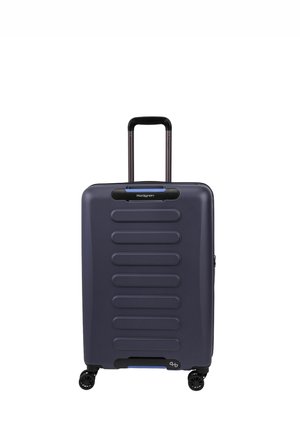 Valise rigide bleu foncé avec poignée télescopique et quatre roues noires multidirectionnelles, debout sur un fond blanc.