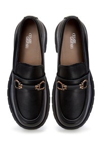 Mocassins en cuir noir à semelles épaisses, bouts arrondis et détails métalliques dorés en forme de mors, signés "Cesare Gaspari" sur des semelles intérieures couleur beige.