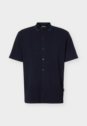 Tengerészkék rövid ujjú, gombos galléros póló texturált anyagból, bal mellrészen kis hímzett logóval.