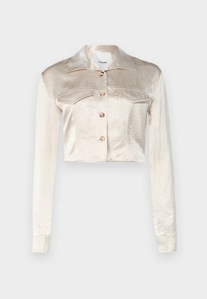 Chaqueta de satén corta en un suave beige con cuello de pico, cierre delantero de botones, dos bolsillos en el pecho y mangas largas.