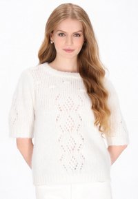 Biały sweter z krótkim rękawem o miękkiej, puszystej fakturze, z wzorami o otwartym splotcie oraz okrągłym dekoltem. Uwydatniony delikatnymi detalami.