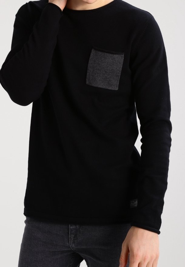 Svart långärmad skjorta med en grå bröstficka, tillverkad av mjukt tyg. Har en rund halsringning och en slim fit-design.