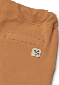 Pantaloni jogger in cotone di un caldo colore arancione con tasca posteriore applicata ed etichetta tessuta. Texture morbida con vita elastica per il massimo comfort.