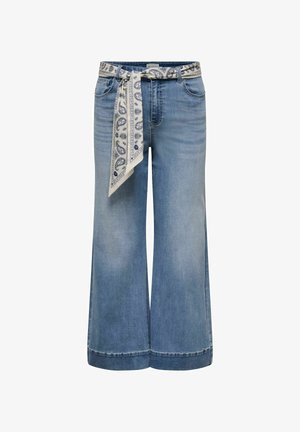 Hellblaue Jeans mit weitem Bein, aufgesetzten Taschen vorne, umgekrempelten Säumen und einem weißen Gürtel mit Paisley-Muster, der an der Taille gebunden ist.