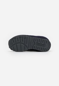 Black athletic shoe sole with textured gripping patterns, featuring a rounded toe and a slight heel elevation, made from rubber material.