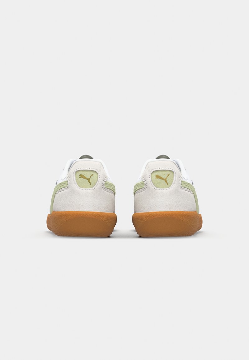 Weiße und grüne Sneakers mit einer hellbraunen Gummisohle, ausgestattet mit einem glatten Lederobermaterial und Suede-Akzenten, runder Form und Logo-Detail an der Ferse.
