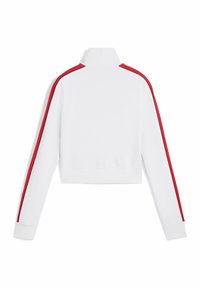 Sweatshirt blanc court avec un col haut, des manches longues, des bandes latérales rouges et des accents noirs le long des coutures. Texture de tissu douce.