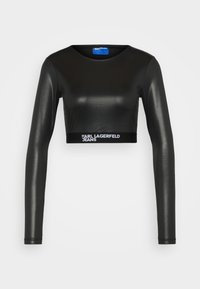 Mustat lyhyt hihaisat paita kiiltävästä, joustavasta kankaasta. Siinä on pyöreä pääntie ja logonauha, jossa lukee "KARL LAGERFELD JEANS" valkoisella.