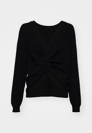 Black knitted sweater featuring a twisted front design, long sleeves, and ribbed texture, contrasting smooth panel at the back.