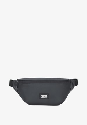 Czarna, wodoodporna nerka wykonana z wytrzymałego materiału. Posiada zamek błyskawiczny i małą naszywkę z logo. Płaski, zaokrąglony kształt.