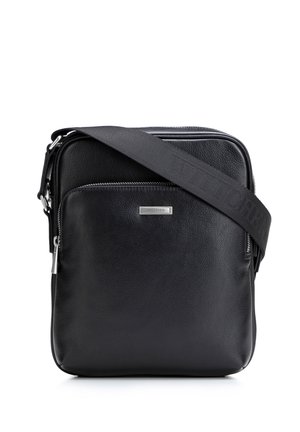 Czarna skórzana torebka na ramię z przednią kieszenią na zamek, srebrną płytką z logo oraz regulowanym czarnym paskiem z tkaniny z wytłoczonym nazwą marki.