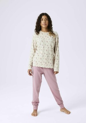 Lange mouwen crema top met roze bloemenprint, gecombineerd met lichtroze joggingbroek met opgezette enkels. Zachte stof, relaxte pasvorm.