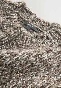 Pruun ja kreemi värvi kudumine, millel on kõrge kaelus, tekstuuriga ja paksu mustriga, kaeluses silt "NEXT".