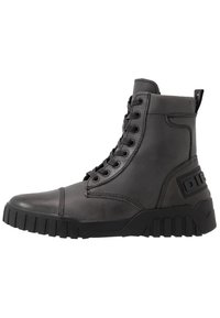 Bota alta de cuero negra con suela de goma gruesa, parte delantera con cordones y detalle de marca en el talón.