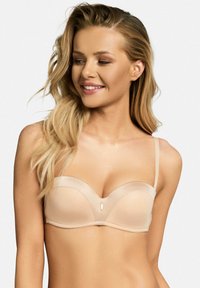 Beżowy stanik z wyściółką, z przezroczystymi miseczkami, wsparciem w postaci fiszbin i gładką teksturą. Ozdobiony małym akcentem dekoracyjnym na środku.