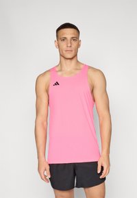 Ružový športový tielko vyrobené z ľahkého materiálu, s okrúhlym výstrihom a čiernym logom Adidas na hornej ľavej strane. Skombinované s čiernymi šortkami.