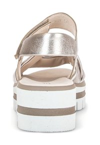 Sandali metallici oro con una spessa suola bianca. Il design presenta cinghie incrociate e una soletta imbottita per il comfort.