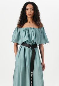Abito teal senza spalline con tessuto fluido, scollatura arricciata e cintura nera con la scritta "SEN MUSE". Include tasche laterali.