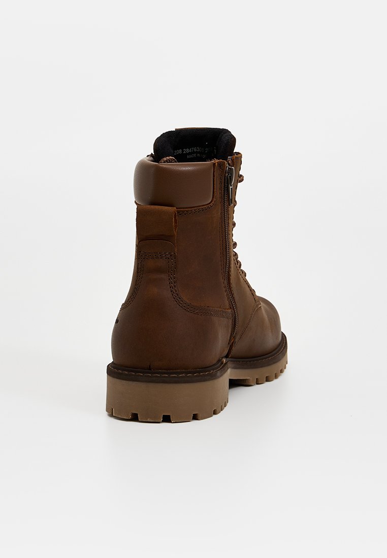 Braune Leder-Schnürstiefel mit seitlichem Reißverschluss, gepolsterter Kragen und dickem Gummisohle, von hinten auf weißem Hintergrund betrachtet.