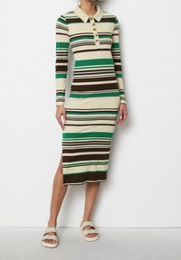 Prążkowana sukienka z długim rękawem z kołnierzykiem, guzikami i poziomymi paskami w zielonym, brązowym, kremowym i różowym kolorze; szczegół z rozporkiem po boku.