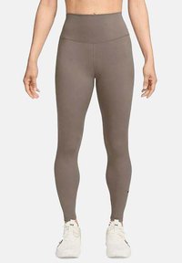 Leggings marron taille haute en tissu extensible avec une texture lisse. Présente un branding minimal près de la cheville. Convient pour les vêtements de sport.