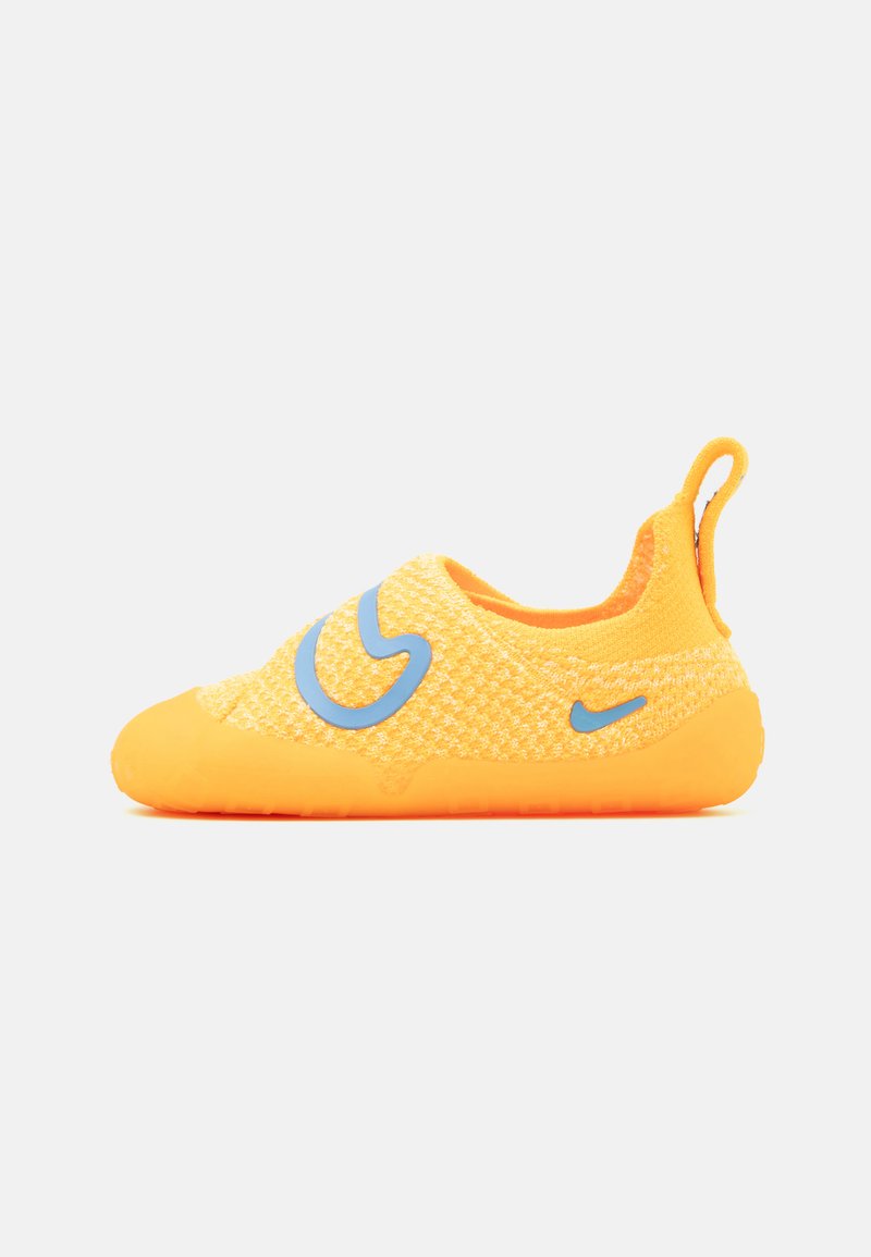 Gelbe Slipper mit einem strukturierten Strickobermaterial, orangefarbener Gummisohle und blauer Logobesetzung an der Seite. Mit einer Pull-Tab an der Ferse.