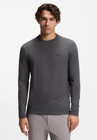Langärmeliges Rundhalsshirt in Dunkelgrau aus glattem Stoff. Verfügt über ein dezentes schwarzes "BOSS"-Logo auf der Brust.