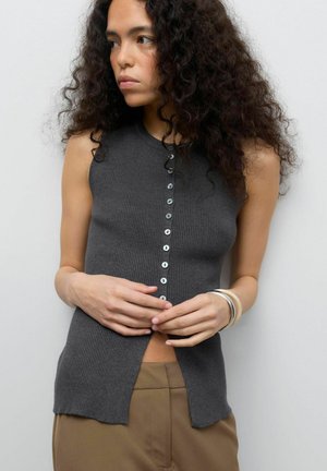 Haut sans manches en ribbed gris avec un col rond, comportant une fermeture à boutons sur le devant et des fentes sur les côtés. Texture lisse, boutons à finition mate.
