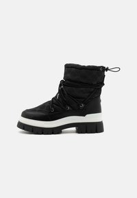 Bottines noires à bout rond, avec une tige rembourrée et une semelle épaisse blanche. Présente une surface texturée et un cordon de serrage réglable en haut.
