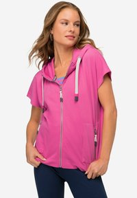 Felpa rosa con zip e maniche corte, dotata di cappuccio, due tasche con zip e lacci a contrasto. Realizzata in tessuto morbido.