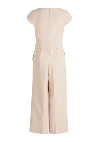 Tuta beige con maniche a cappuccio, corpetto aderente, pantaloni a gamba larga e zip sul retro. Tessuto morbido con vita cinturata.