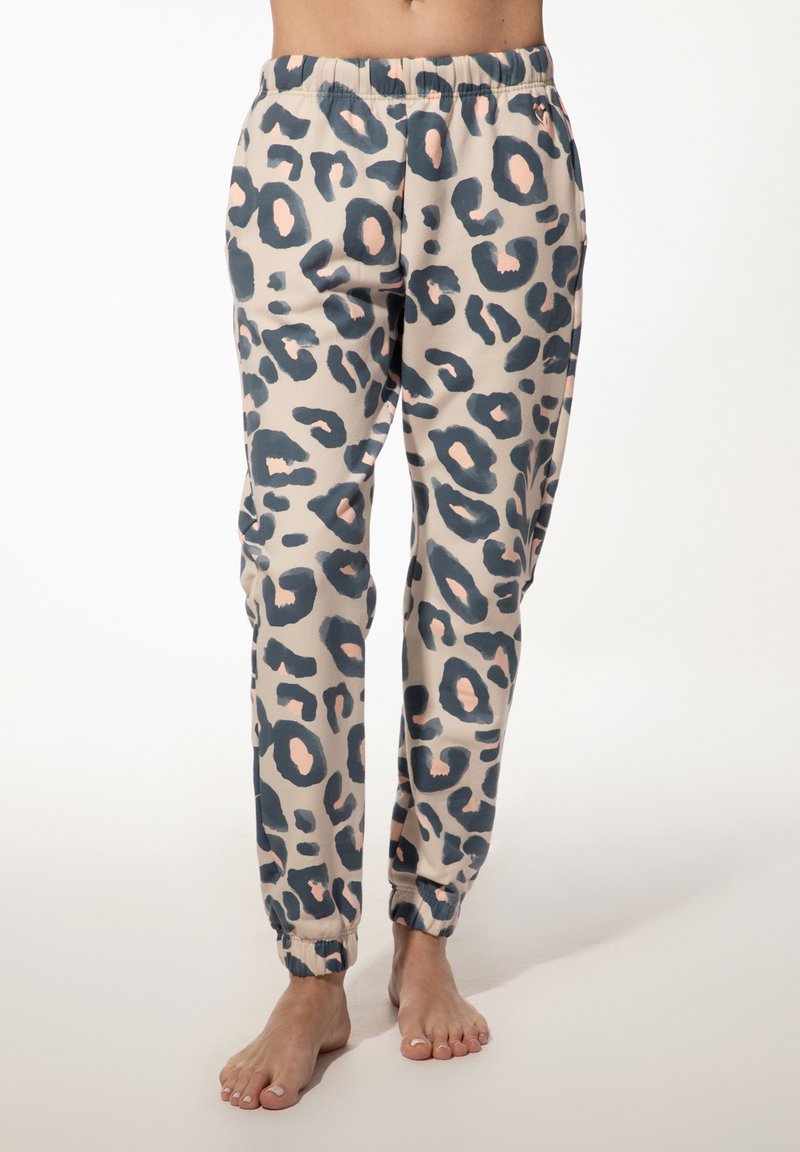 Joggingbroeken met luipaardprint in lichtbeige, met donkerblauwe en blushvlekken, elastische tailleband en enkelkappen. Zachte stoftextuur.
