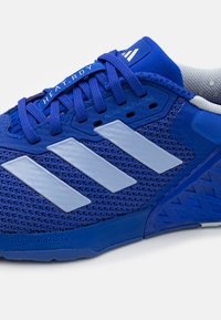 Blue athletic shoe with mesh upper, three reflective white stripes, and textured blue sole. Features adjustable lacing and "HEAT.RDY" branding.