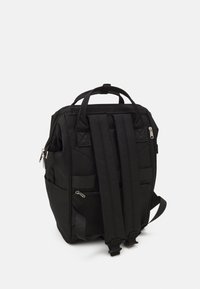 Czarny plecak z regulowanymi paskami, wieloma zewnętrznymi kieszeniami, rączką u góry i zamykanymi na zamek przegrodami. Wykonany z trwałego materiału.