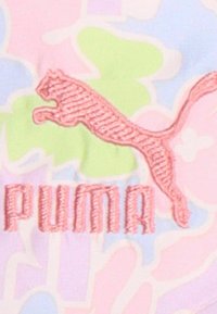 Logo de Puma en bordado rosa sobre una tela de patrones abstractos en tonos pastel, con matices verdes, rosas y azules. Textura suave y diseño dinámico.