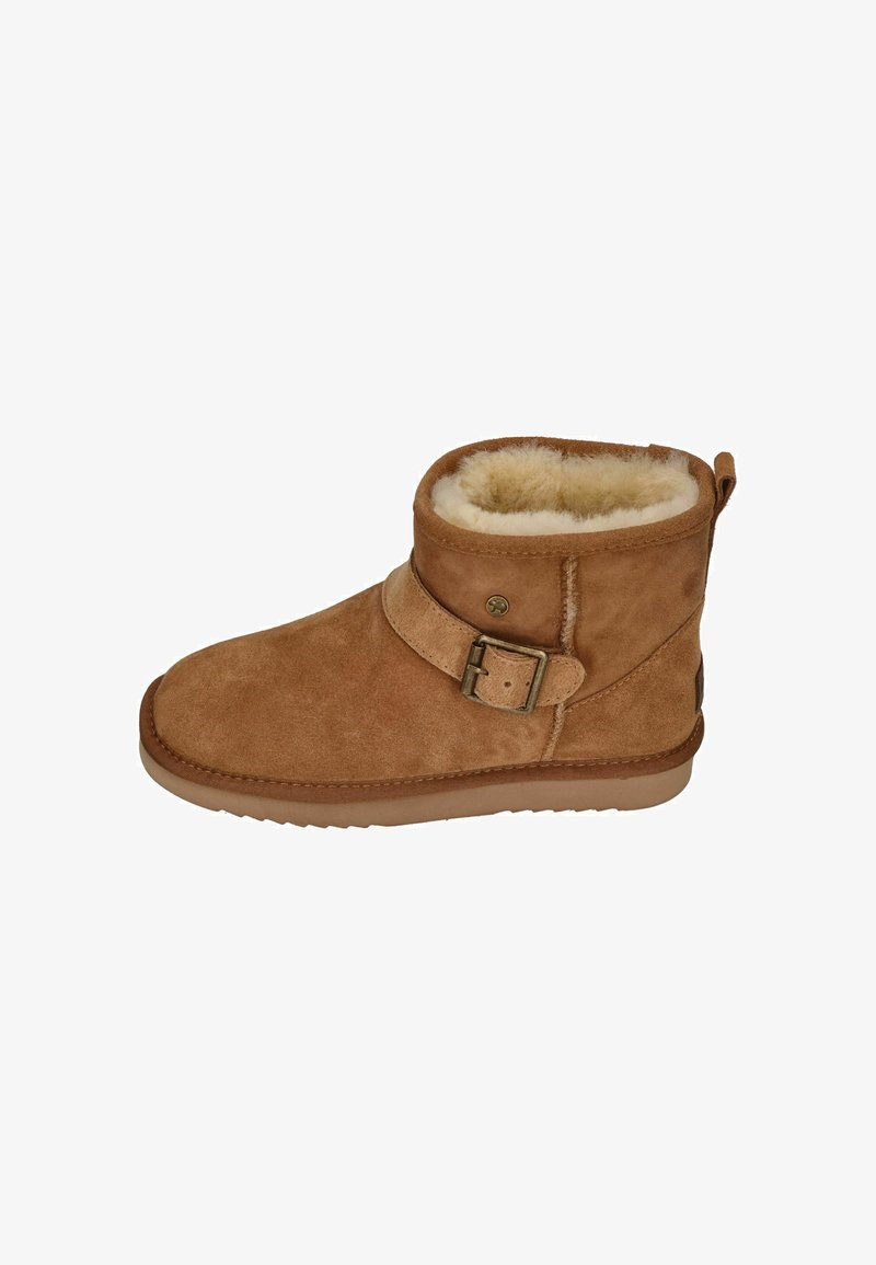 Tanfarbene Wildlederstiefeletten mit Kunstfellfutter, Riemen- und Schnallenverzierung, rundem Zeh und strukturiertem Gummisohle. Kurze Schafthöhe.