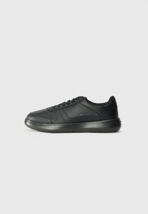 Czarny niski sneaker sznurowany z grubą podeszwą, z delikatnym przeszyciem i małym logo marki z boku.