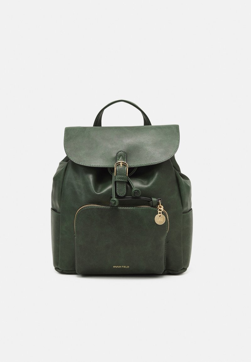 Green faux leather backpack with a flap, buckle closure, front pocket, and gold hardware accents. Smooth texture with a structured shape.