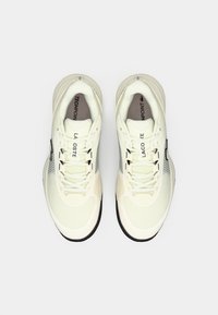 Lacoste Techpoint kedas, ar krēmkrāsas sieta augšdaļu un melnu zoli, izceļas ar apaļām auklām, zīmola nosaukumu uz mēles un sānu, kā arī teksturētām akcentiem.