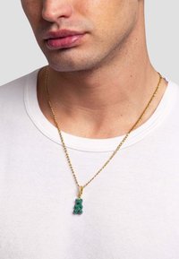 Guldkæde med en grøn gummibear vedhæng. Vedhænget er glansfuldt med afrundede former og hænger fra en snoet kæde.