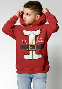 Red hoodie featuring a Santa-themed graphic: white fur accents, a black belt with a gold buckle, and a candy cane design. Text reads "Team Santa."