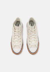 Vysoké tenisky z off-white plátna s gumovou podrážkou. Funkcie zahŕňajú okrúhly špičku, čierny lem a kontrastnú gumovú podrážku. Systém zaväzovania na šnúrky.