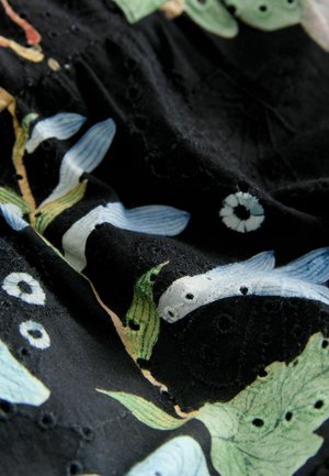 Čierna látka s kvetinovým vzorom a modrými listami a zelenými akcentmi. Povrch má vyšívané detaily a malé výrezy.