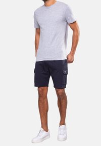 Gray short-sleeve t-shirt paired with navy cargo shorts featuring side pockets, worn with white sneakers. Casual, comfortable outfit design.