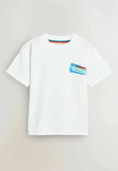 T-shirt blanc à manches courtes avec une poche décorée de plusieurs étiquettes colorées superposées en bleu, rouge et jaune. Tissu en coton, col rond.