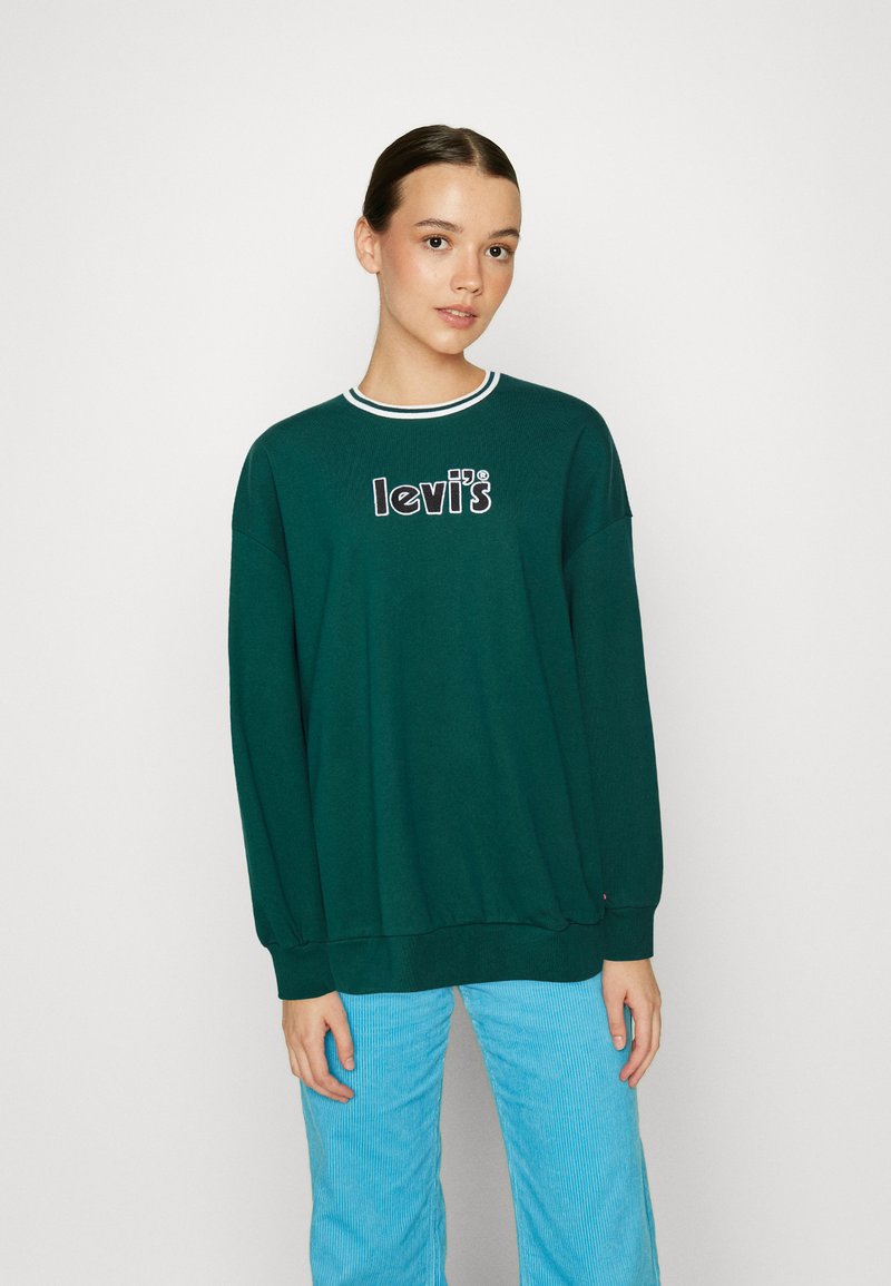 Green sweatshirt with white and blue collar, features "levi's" logo in black and white. Long sleeves and relaxed fit. Pairing with light blue pants.